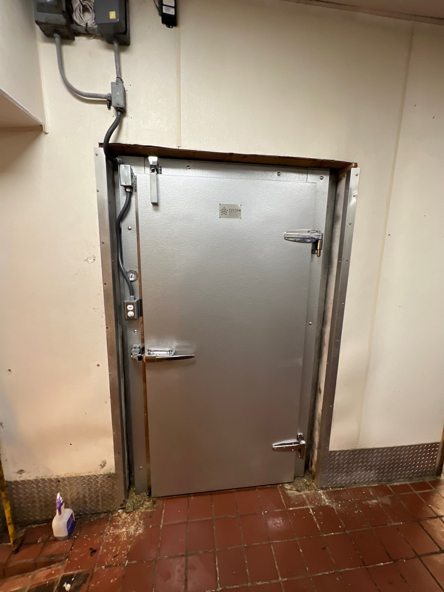 Replacement walk-in freezer door installed with a rebuilt frame