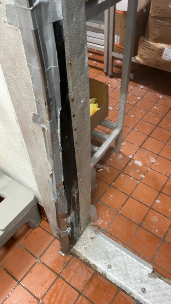 Walk-in freezer door jamb patched with duct tape